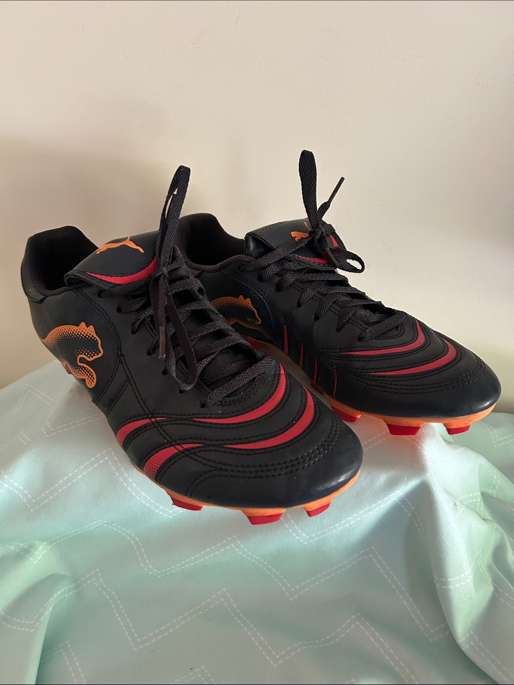 Puma Black Soccer Cleats with Red and Orange Accents